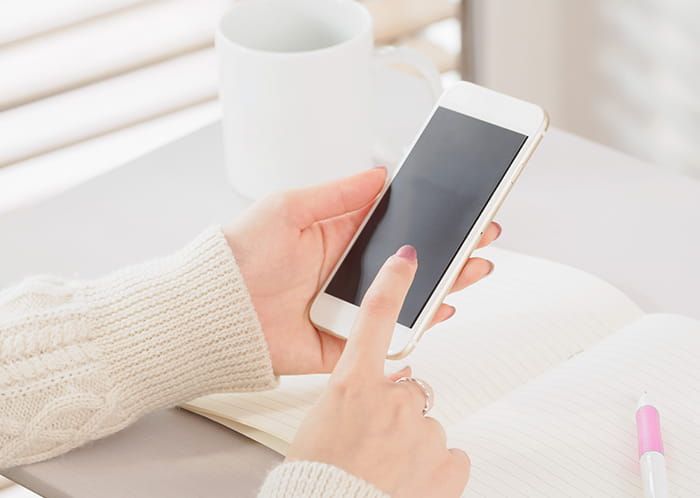 スマホを操作する女性の手